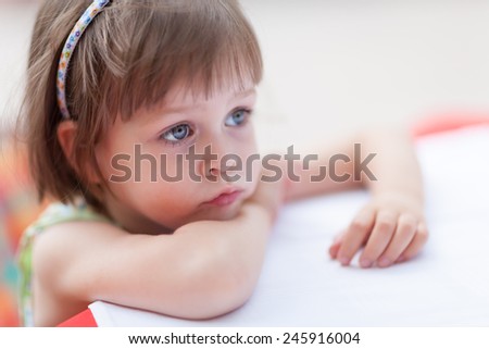 Cute little girl looking for someone or something at coffee table. Closeup portrait with shallow depth of field