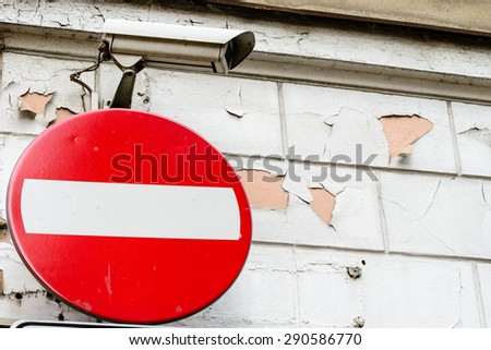 No entry sign and security camera - against rough wall background