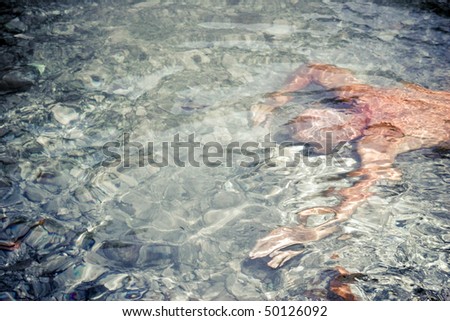 Clean river water. Unrecognizable man swimming.