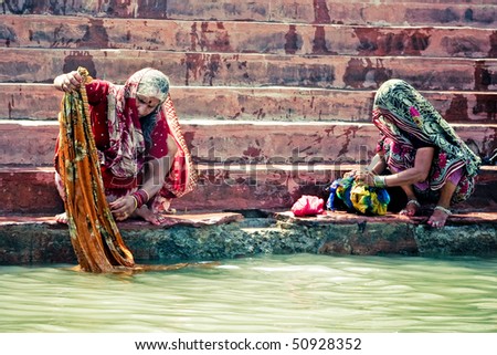 HARIDWAR - APRIL 11: Women washing their saris and clothing in holy Ganga river during Kumbha-mela festival. April 11, 2010 in Haridwar, India.