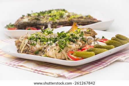baked perch fish with cheese, potato ans onions served with boiled eggs, paprika and gherkins