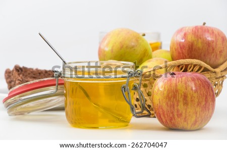 Glass cup of tea with lemon, basket of apples, honey and chocolate cake