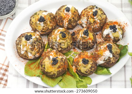 Stuffed white mushrooms with green olives, cheese and black caviar