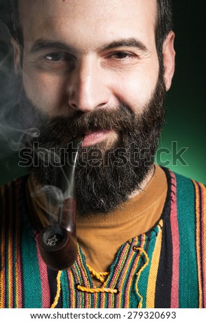 Portrait of beard man smoking tobacco pipe. Pipe is smoke/Beard man smoking tobacco pipe