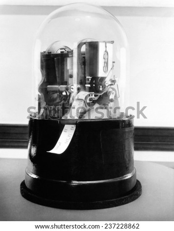 Classic 1920\'s stock ticker with a glass dome Stock tickers were specialized telegraphs that conveying stock prices Ca.