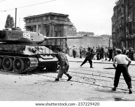 Anti-Communist riots in East Germany: An East Berliner throws stones at a Russian tank during the first violent resistance.