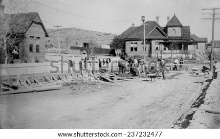 Mormon homes in Northern Mexico Men are working in a wide street with Brick homes and utility lines The American Mormon settlements in Mexico were prosperous communities with canals, Ca. 1910.