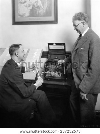 Stock brokers with a new box shaped stock ticker in May 1929.