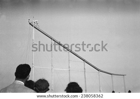 Daredevil preparing to dive into water from cycle down an elevated incline, by Lee Russell, state fair, Donaldsonville, Louisiana, November, 1938.