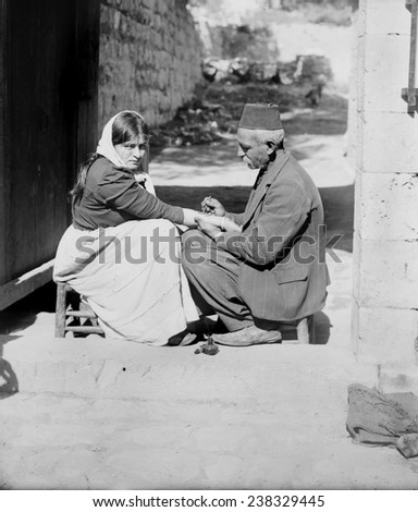 Woman being tattooed by a man in a fez,'Tattoing a pilgrim', Jerusalem, American Colony Photo Department, 1900-1920.