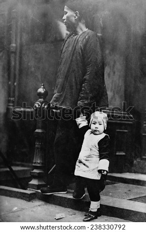 Chinese New Year, Chinese child with an adult on step outside of building, Chinatown, New York City, photograph, 1909.