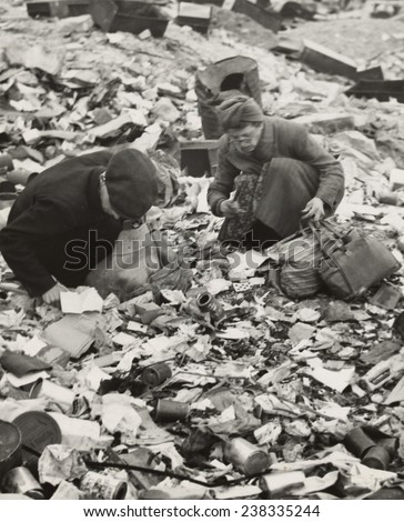 World War II, two Germans searching for food in a garbage dump,\'Hunger, the price of defeat\', Berlin, Germany, photograph by Emil Reynolds, 1945.