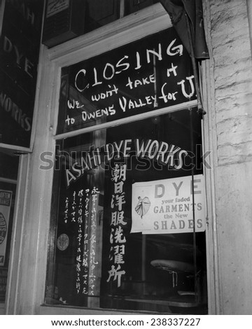 World War II, Shop window of Asahi Dye Works with sign: \'Closing, we won\'t take it to Owens Valley for U\', before Japanese were evacuated from Little Tokyo to Los Angeles, California, April, 1942