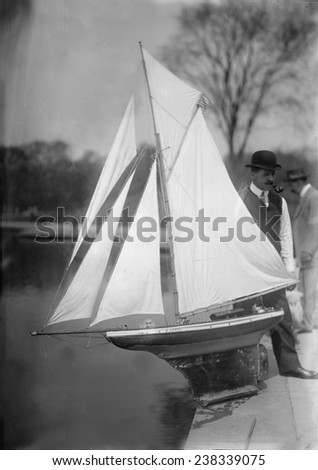 New York City, man with toy yacht in Central Park, ca 1910s.