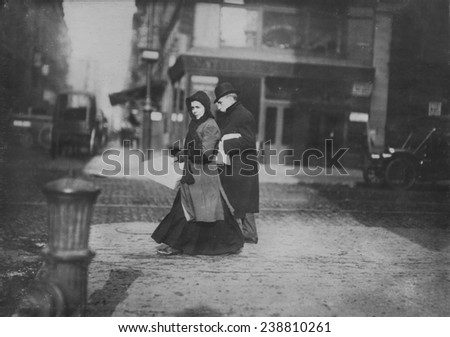 Woman carrying flowers home, West Houston Street, caption: \'A short time ago she told me they were not going to make flowers any more\', New York, photograph by Lewis Wickes Hine, February, 1912