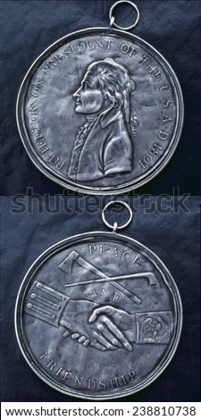 Thomas Jefferson Indian Peace Medal, relief portrait of President Thomas Jefferson in profile (obverse), clasped hands under crossed peace pipe and tomahawk (obverse). Silver coin, 1801