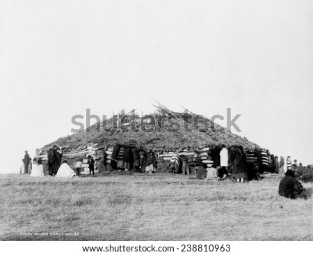 Sioux Indian dance house, log building with sod roof and American Indians outside, photograph, 1911