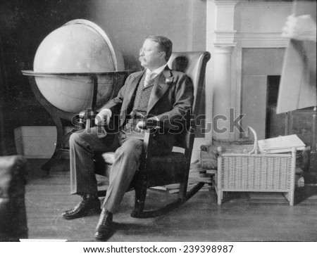 Theodore Roosevelt, at the end of his presidency, seated in rocking chair, by large globe. During Roosevelt\'s presidency, the United States was recognized as a world power.