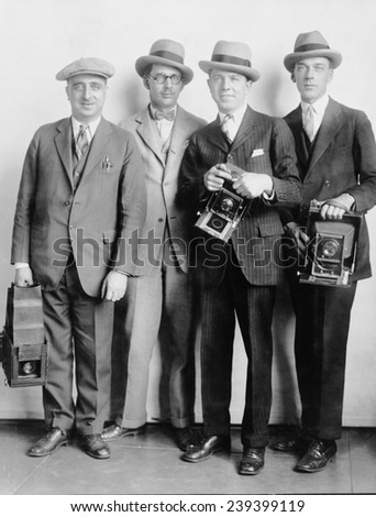 Four members of the White House News Photographers\' Association, holding cameras in 1924.