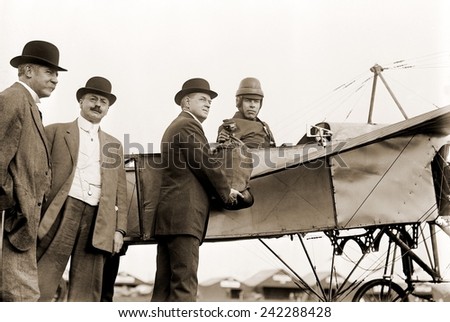 The first U.S. air mail pouch is handed to helmeted pilot Earle Ovington by Postmaster General Frank H. Hitchcock on Nassau Boulevard, Long Island, September 23, 1911.