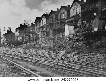 Old wooden housing with latrines in backyards lining the railroad tracks in Cincinnati, Ohio. In the 1930\'s, substandard homes without interior bathrooms housed the poor. 1935 photo by Carl Mydans.