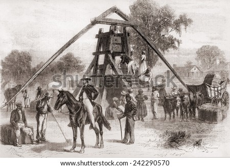 Cotton press in operation in the South after the U.S. Civil War. The machine had a large vertical screw turned by horses or mules harnessed to long poles. CA 1875.
