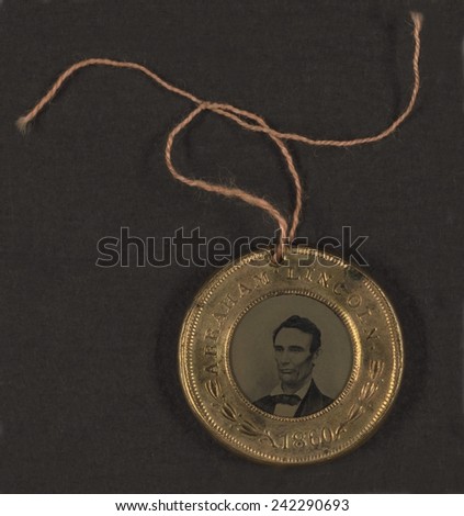 Campaign button for 1860 presidential election, bust tintype portrait of Abraham Lincoln in a metal casing. Vice Presidential candidate, Hannibal Hamlin\'s, portrait is on the reverse side. 1860.