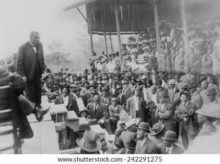 Booker T. Washington addressing a laughing crowd of African American men in Lakeland, Tennessee, during his campaign promoting African American education. Ca. 1900.