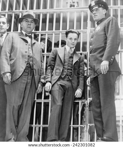 Francis 'Two Gun' Crowley (1911-1932), hand cuffed to a law enforcement officer, as he leaves the jail in Mineola, New York.