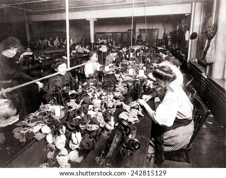 Women workers sewing teddy bears in an sweat shop assembly line. Women are engaged at the sewing machines, while men associated with the operation are in the background. New York City, 1915