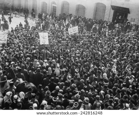 Arab Anti-Zionist demonstration is outside the Damascus Gate in Jerusalem. Jewish people are watching demonstration near door. March 8, 1920.