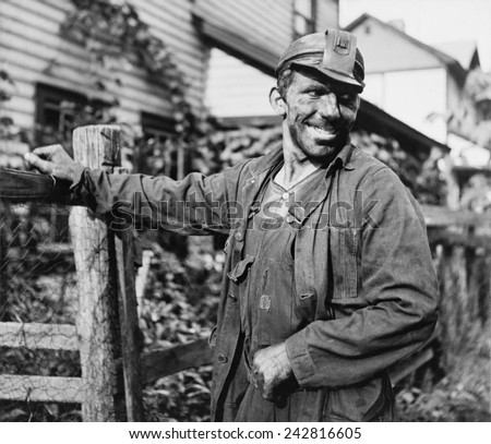 Smiling Polish-American miner, in work clothes and covered with coal dust, arriving home from work in Capels, West Virginia. 1938 photo by Marion Post Wolcott.