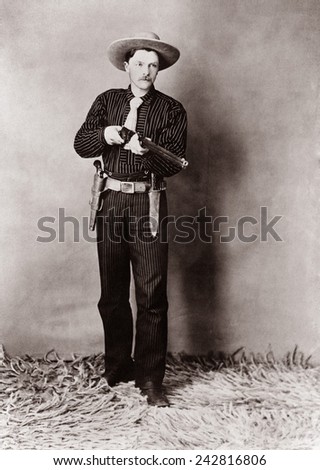 Bill Bennett, Wild West detective, armed with a rifle, revolver and knife. Ca. 1900.