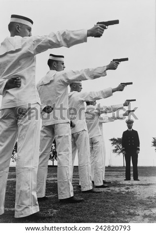 Five cadets at the U.S. Naval Academy, Annapolis, shooting pistols. July 1942.