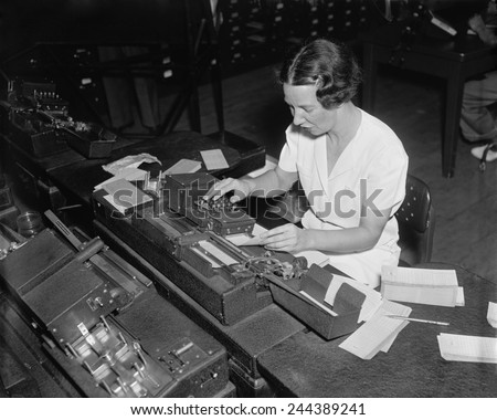 Social Security Administration clerk punching tabulator operation cards, with each hole representing a letter or a numbers. Ca. 1938.