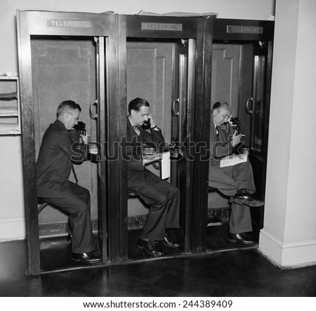 Reporters in telephone booths in White House press room, ca. 1937.