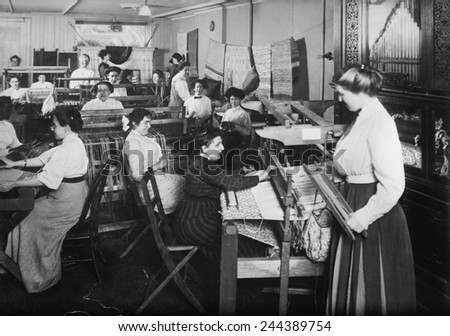Blind women weaving at looms accompanied by an orchestrion, a self playing musical instrument, at right. Photo taken by Byron Company for the New York Association for the Blind.