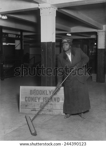 African American woman porter in the New York City Subway sweeping an underground station. Ca. 1910.