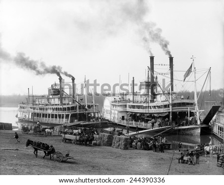 Riverboats on the Mississippi River receiving cargo and supplies at the Vicksburg landing. African Americans provide the hard labor of loading the boats. Ca. 1905.