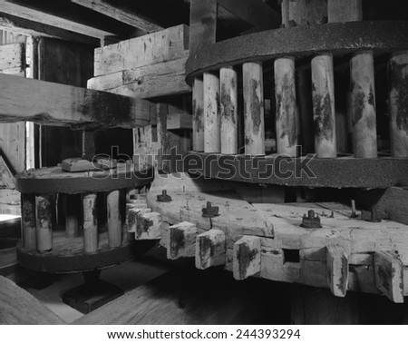 Wooden gears inside an old tide mill. The Great spur wheel and wallower on left, Auxiliary pinon on right. Lefferts Tide Mill was built in 1793 in Huntington, New York State.