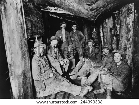 Seven miners pose for a photograph after lunch in the Last Chance Company mine in the Coeur d'Alene region of Idaho. The region was rich in silver, lead, gold and copper. Ca. 1910.