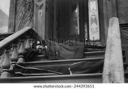 Policeman sleeping on the porch of a New York City brownstone during the strike by wagon drivers of Adams Express, American Express, and Wells Fargo. 1910.