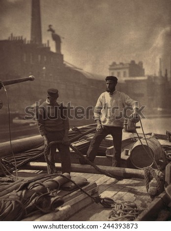 WORKERS ON THE SILENT HIGHWAY 1877 by John J. Thomson 1837-1921 shows two workmen on a barge on the Thames River England. Thomson was one of first social documentary photographers.