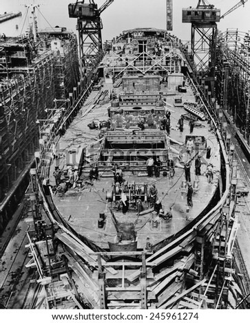 On the fourteenth day of the construction of a Liberty Ship. The upper deck mast houses and after-deck house are in place. Bethlehem Fairfield shipyards near Baltimore Maryland. Ca. 1942-43.