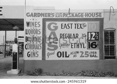 Gardener\'s Cut Rate Package House sign advertising alcoholic beverages and gasoline prices. Waco, Texas, Nov. 1939.