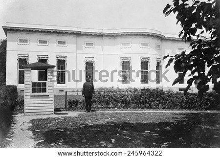 Police box and guard in the rear of the West Wing of the White House. At center left are the three windows of the Oval Office built into the 1902 structure by President William H. Taft. Ca. 1920.