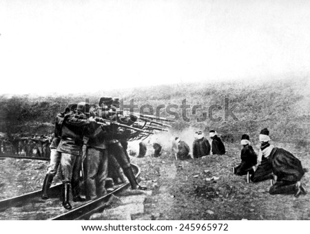 Austrian atrocities in Serbia. A long line of blindfolded and kneeling Serbian men near the Austrian lines were ruthlessly shot at a command. One in five Serbian died during WWI. Ca. 1914-1918.