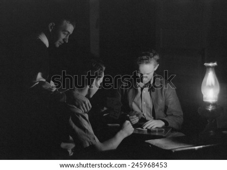Men play cards by the light of a kerosene lantern. Pie Town, Mexico, 1939.