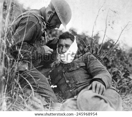 A just wounded American soldier, receiving first-aid treatment from a comrade. WWI. Varennes-en-Argonne, France. Sept. 26, 1918