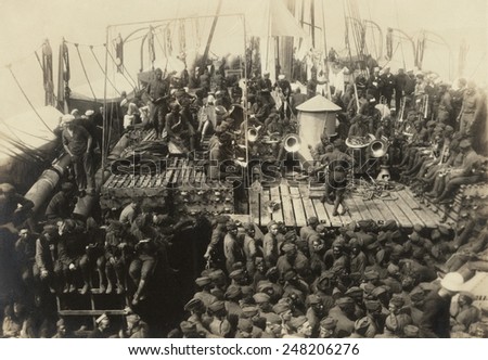 African Americans with white soldiers and sailors on WW1 troop ship. July 18, 1919. Black soldiers with musical instruments have an integrated audience.